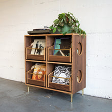 Load image into Gallery viewer, Wooden turntable stand with decorative items against a white brick wall.