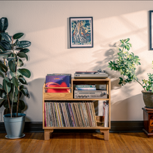Load image into Gallery viewer, Wooden record player with vinyl records, surrounded by potted plants and framed posters on a wall.