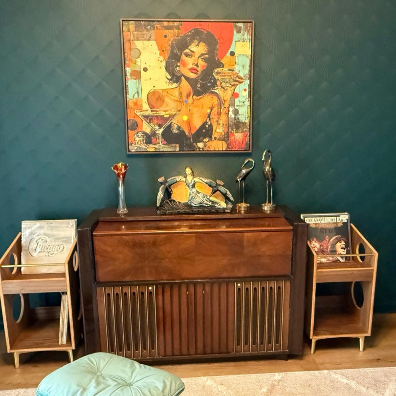 Vintage wooden radio console with decorative items against a teal wall.