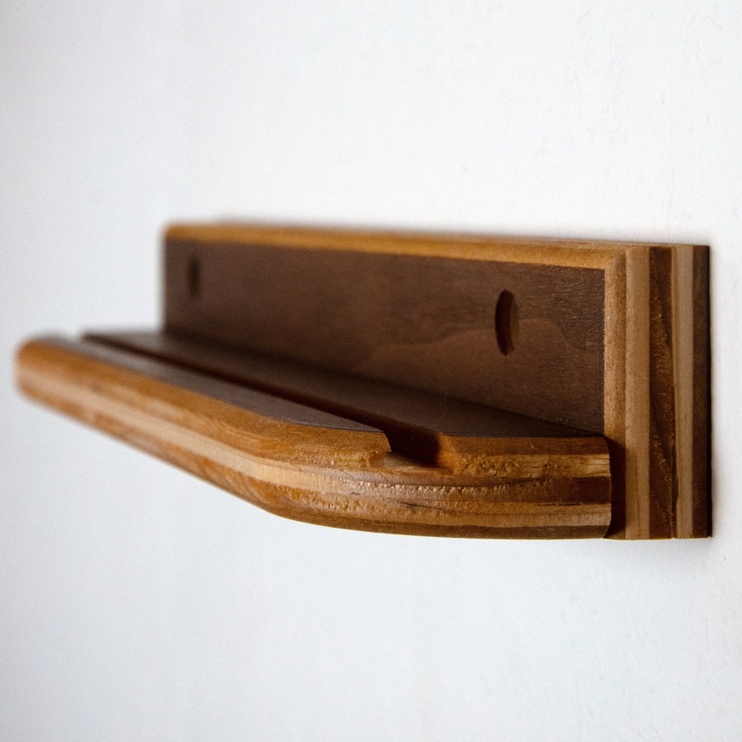 Wooden shelf mounted on a white wall