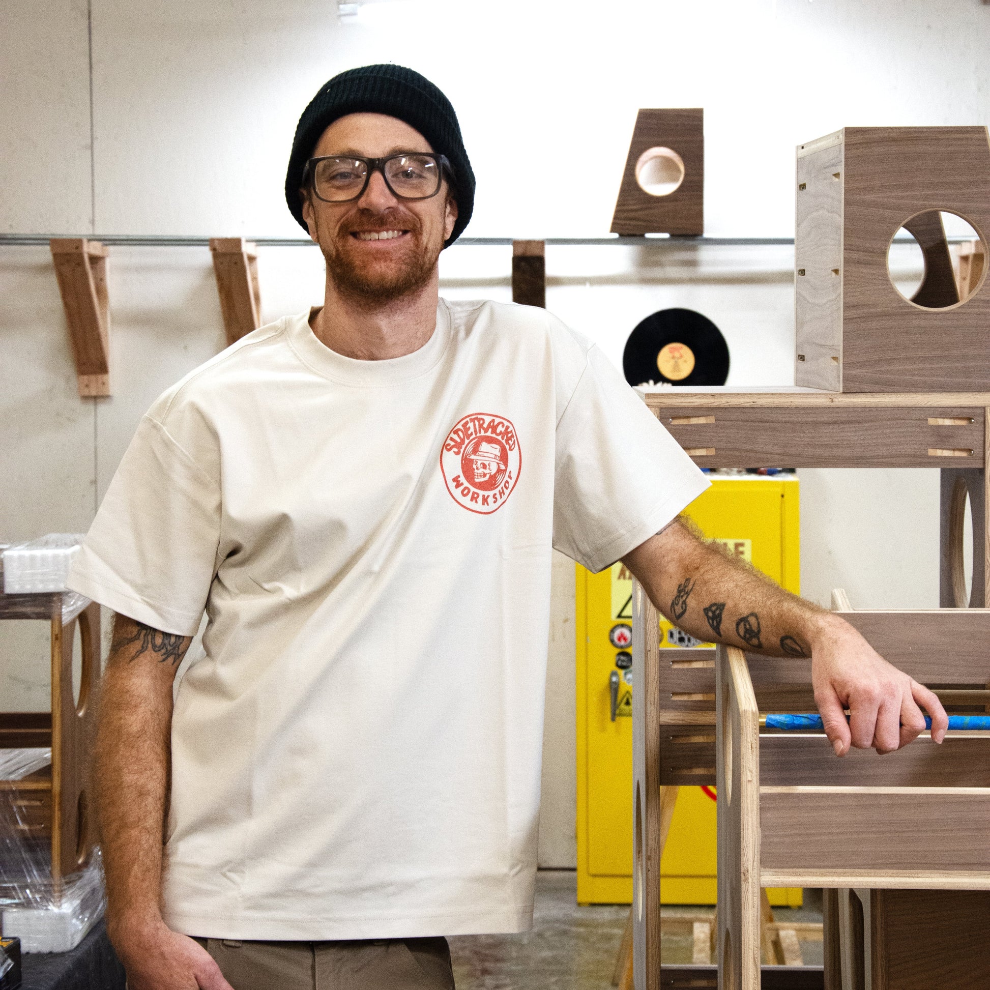 Man standing next to a wooden shelf in an indoor setting