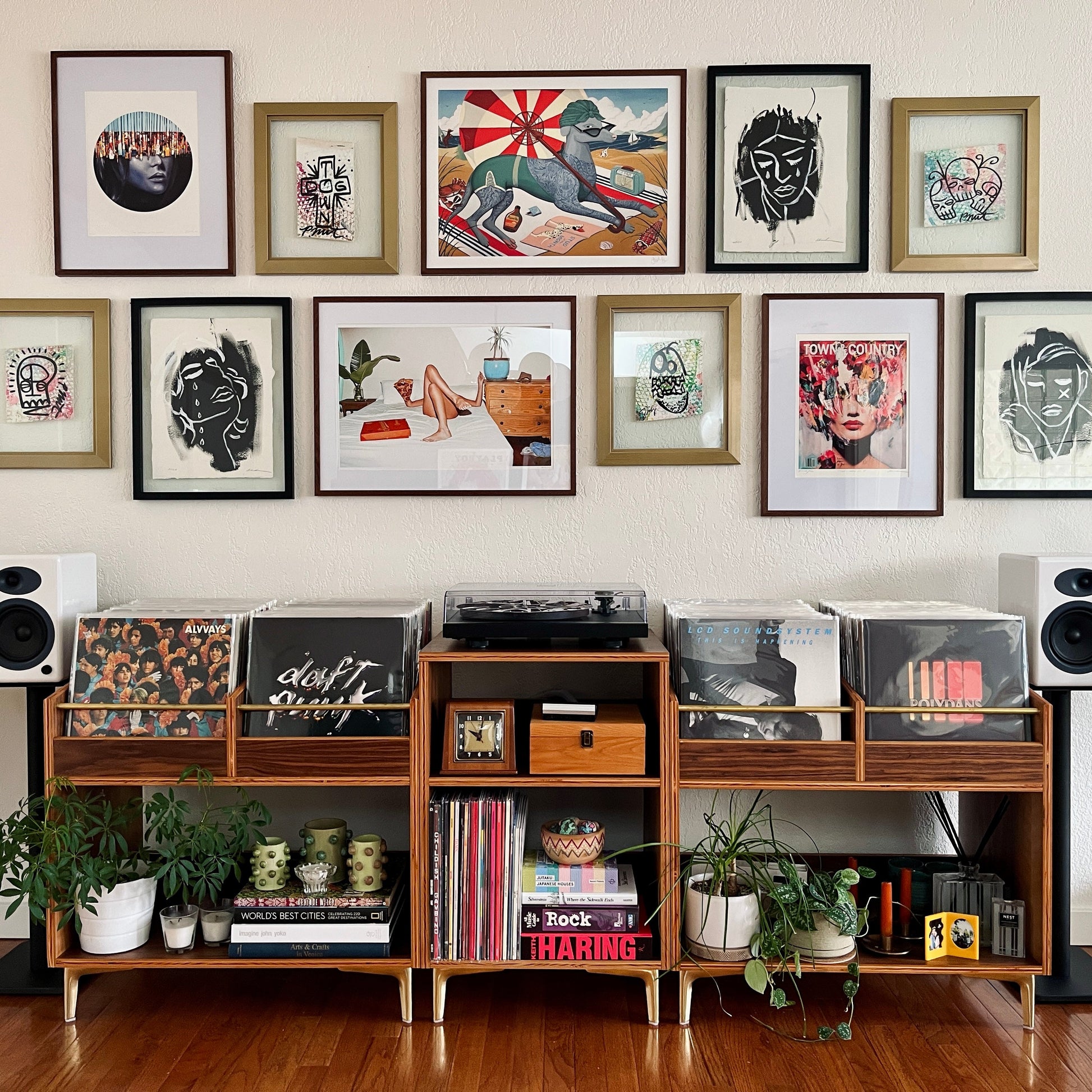 Wooden record player console with framed artwork on the wall