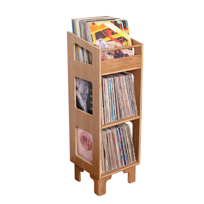 A light natural wood record rack stand holding multiple vinyl records, isolated on a solid white background.