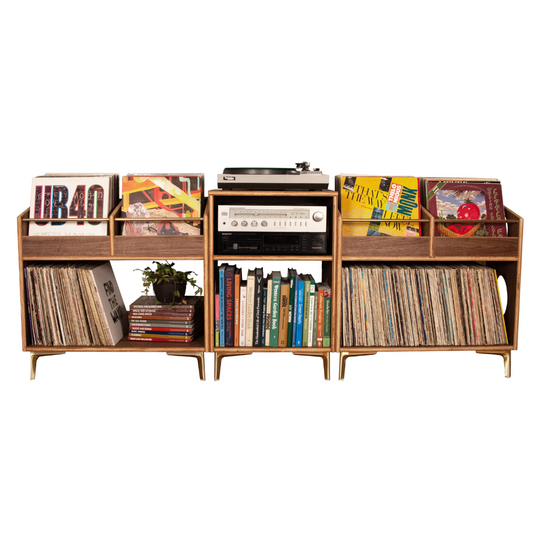 A mid-century modern wooden record shelf and media console with legs, featuring open shelves, a top deck slot with a turntable, and record sleeves displayed on a white background.