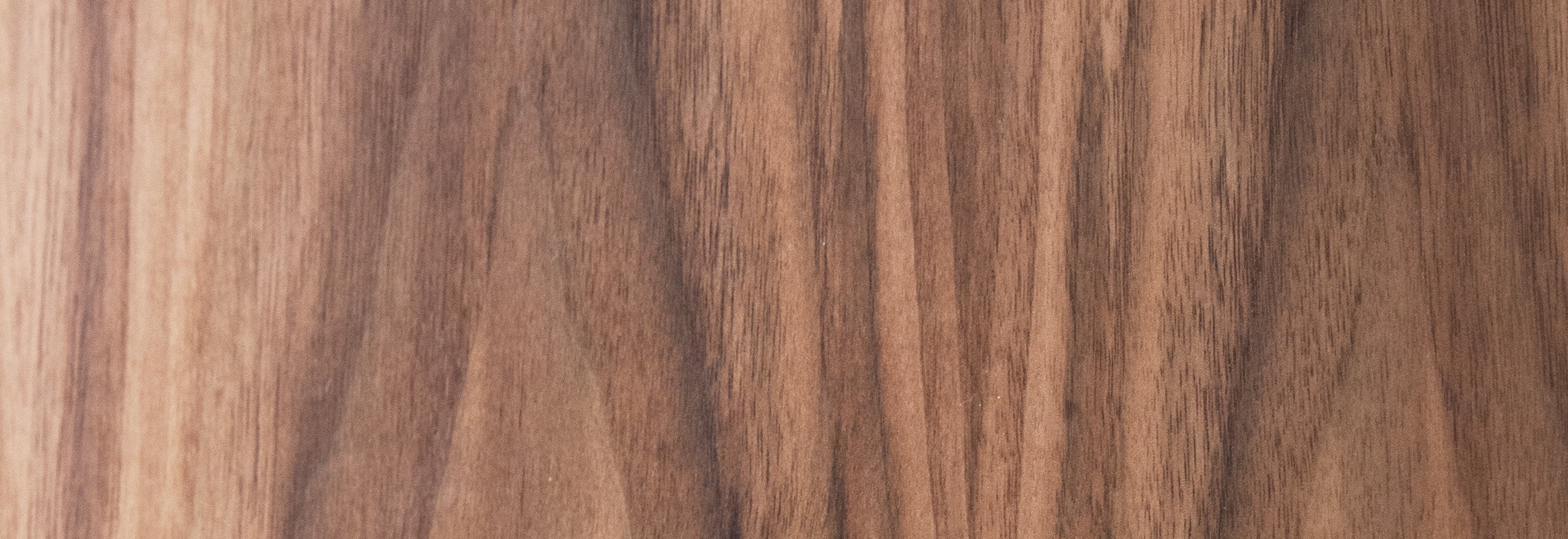 Close-up of a wooden surface with a rich brown color and visible grain pattern.